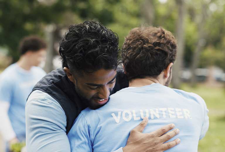 Día Internacional de la Esperanza Voluntarios de Fundación Mapfre abrazándose durante una jornada de acción social.