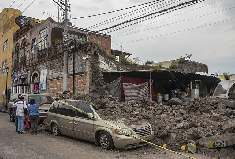 Memoria y solidaridad en México Terremoto en México con edificios dañados y vehículos entre los escombros
